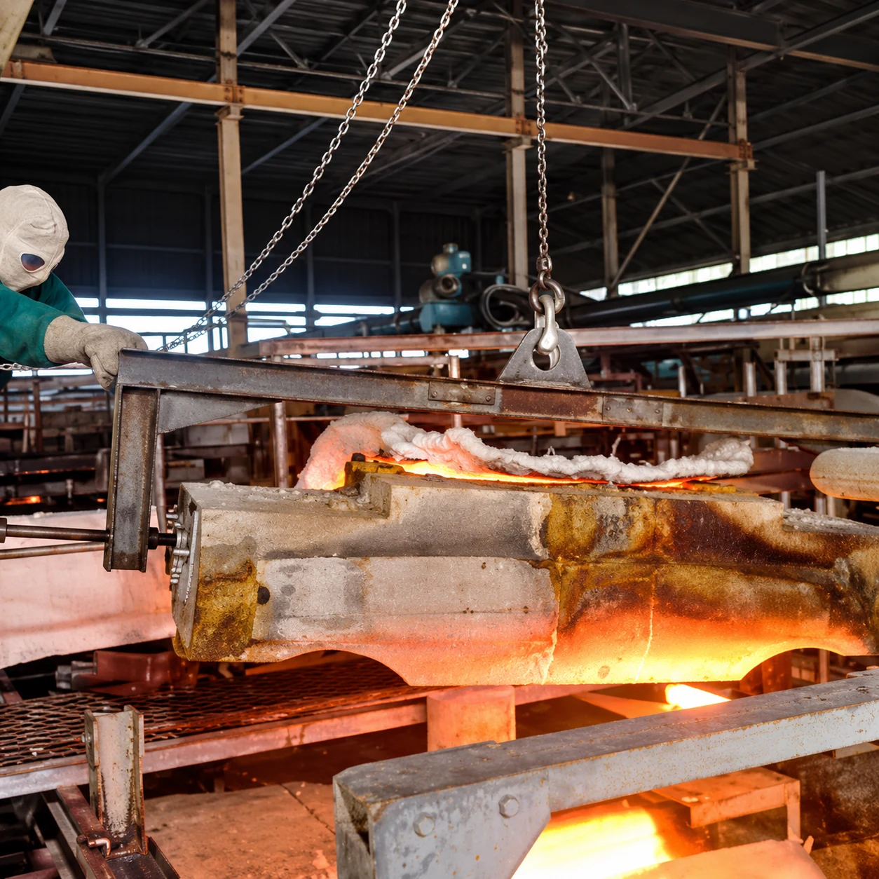 A glowing refractory block lifted from a glass furnace during a hot repair