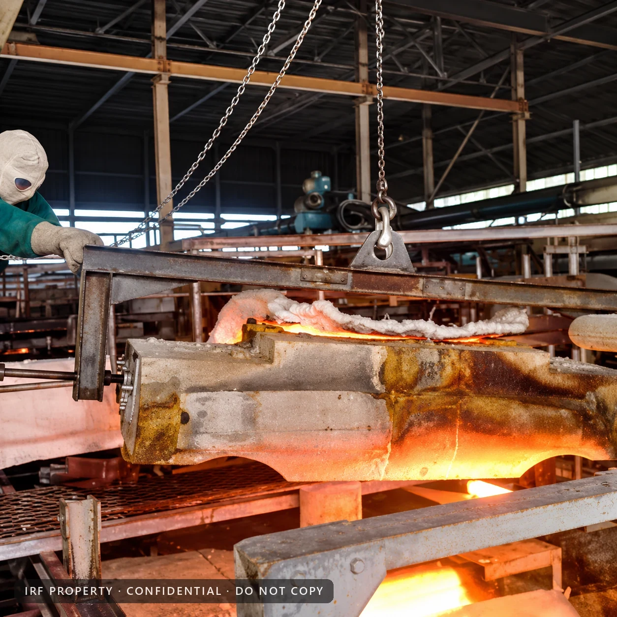 A glowing refractory block lifted from a glass furnace during a hot repair